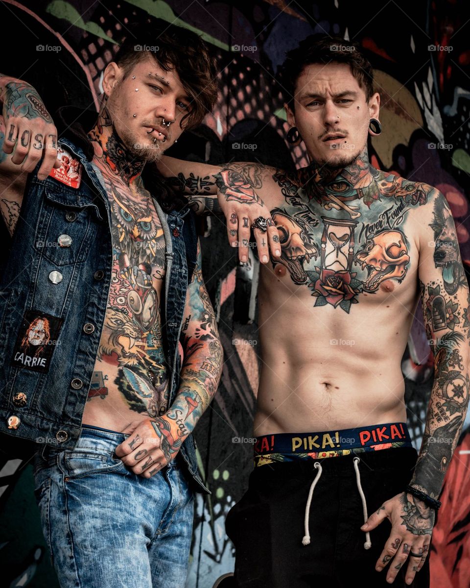 Two guys with tattoos showing off