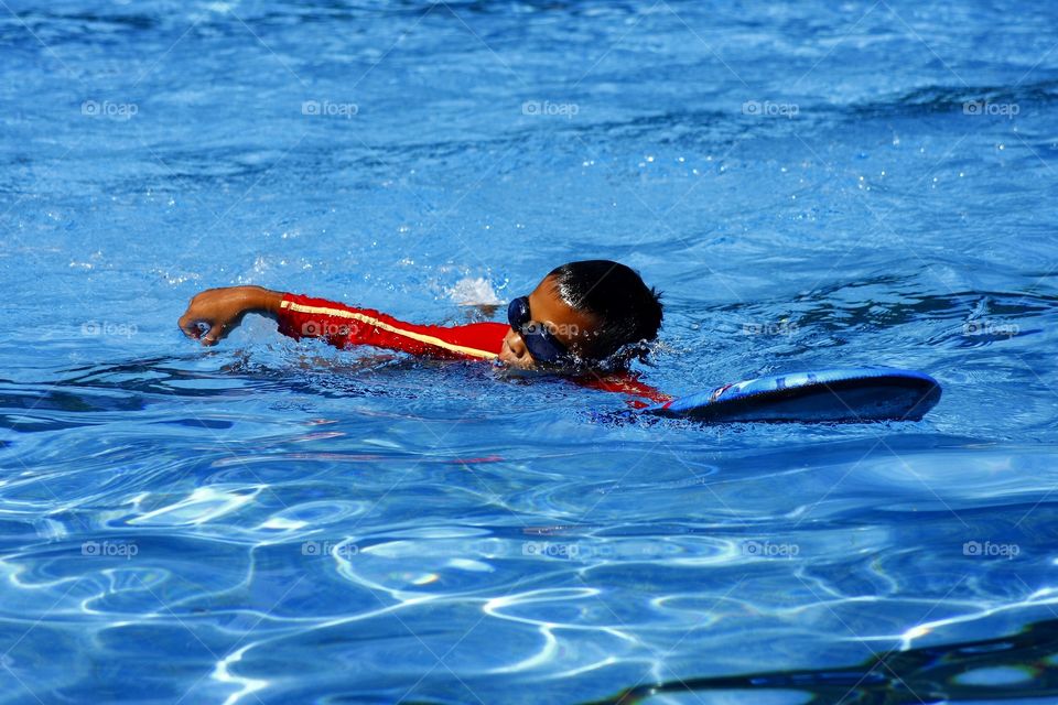 young boy swimming in a pool