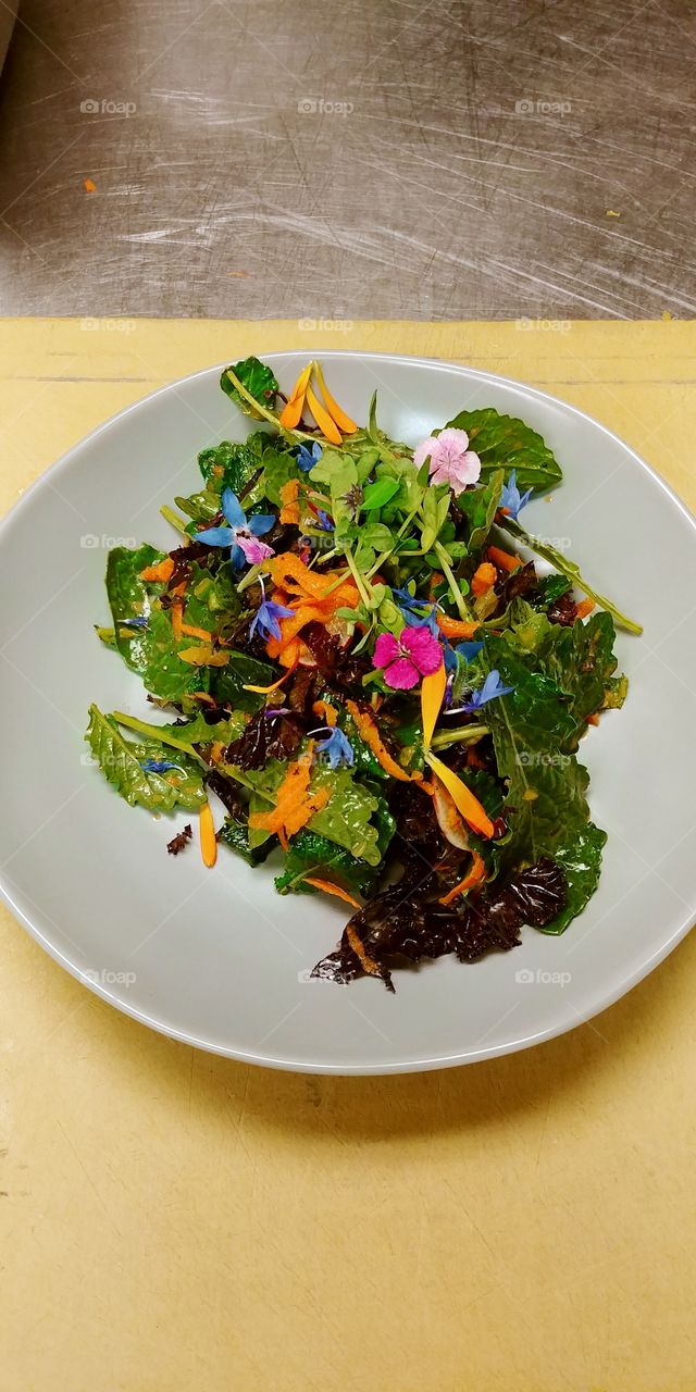 citrus kale salad with pea shoots and edible flowers