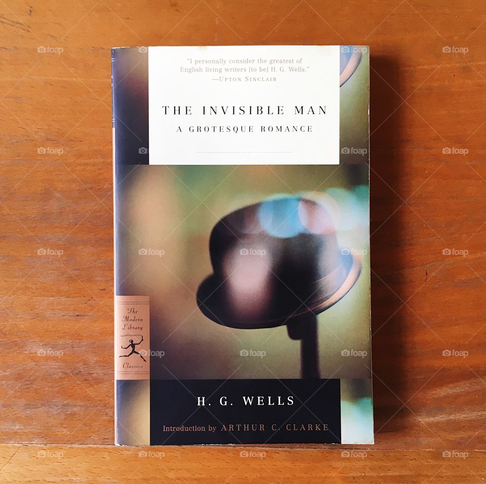 A book, The Invisible Man by H.G. Wells, lies on a wooden desk.