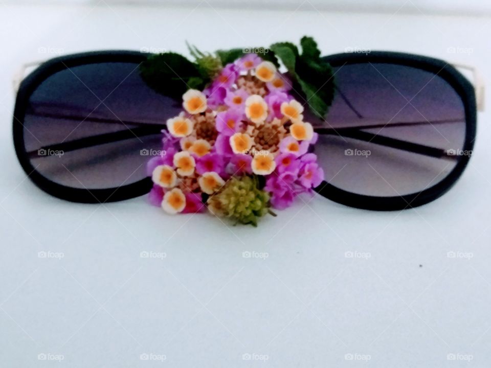 Contraste do óculos com o pequeno buquê, criatividade