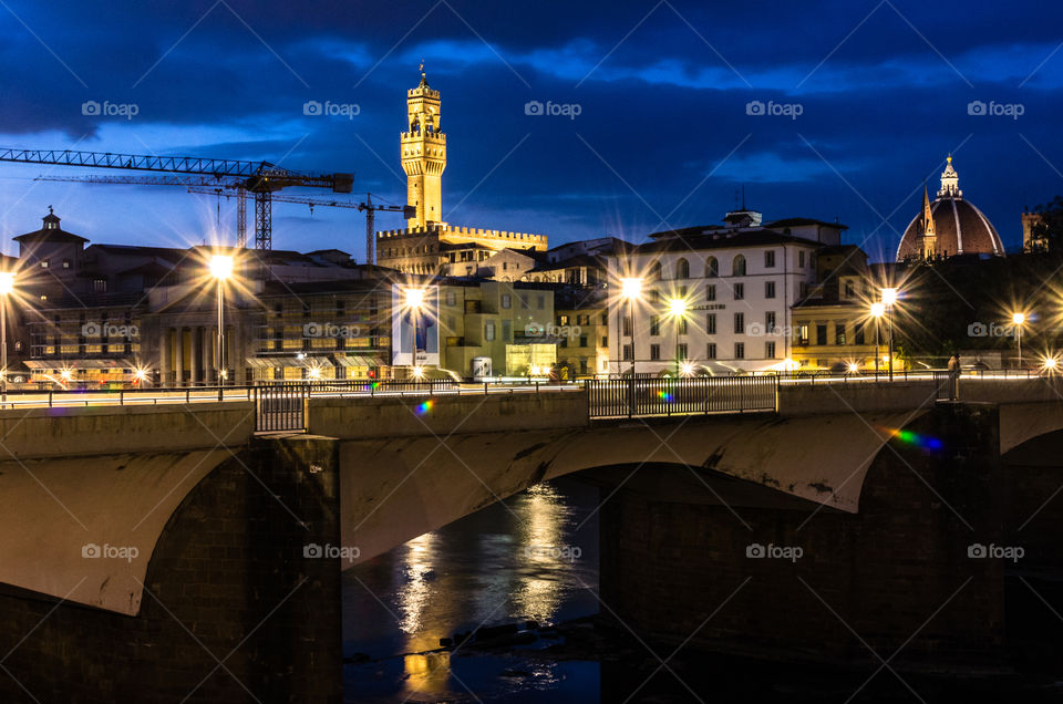 Street lights on a bridge in Florence at night. Ponte alle Grazie over the Arno River. 