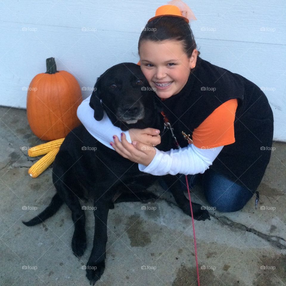 Girl hugging black lab