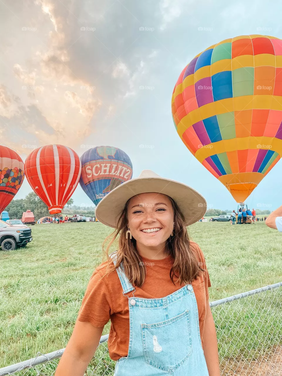 Young boho styled photo shoot with colorful hot air balloons at a fun summer festival. 