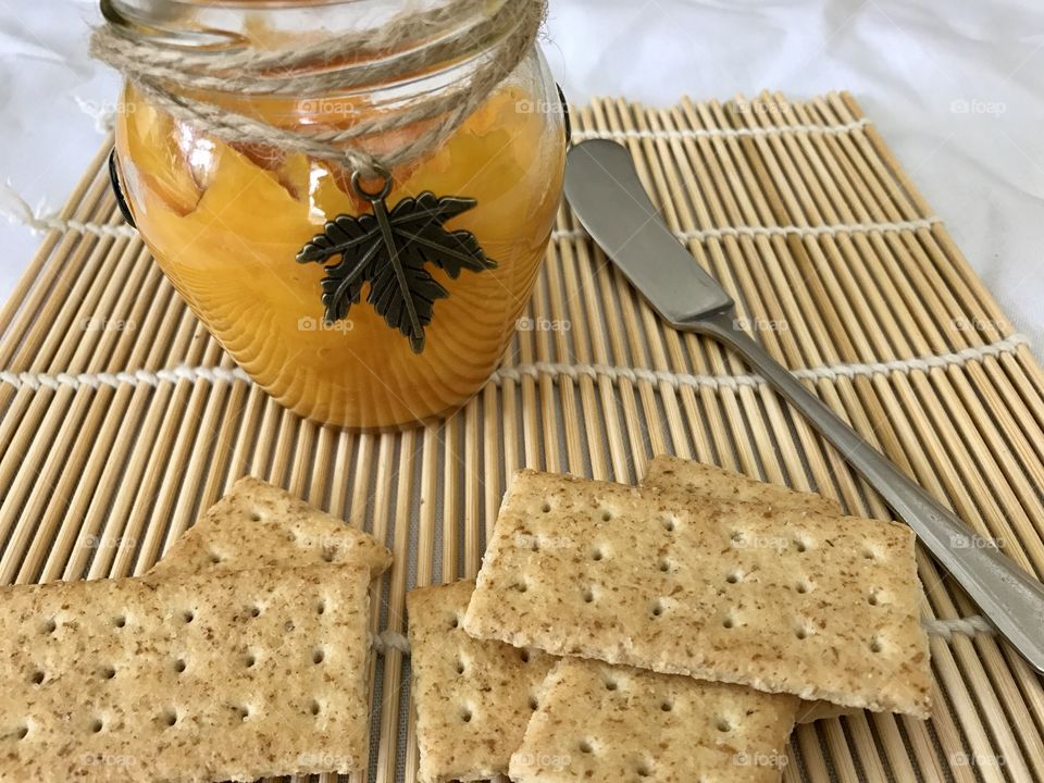 Mango jam with crackers on bamboo plate mat 