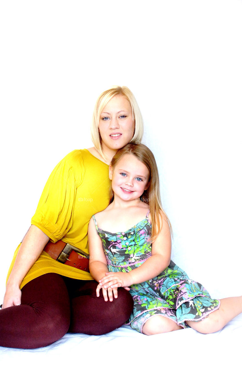 A MOTHER AND DAUGHTER SMILE AT THE CAMERA