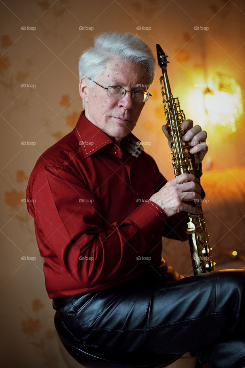 Senior man holding saxophone in hand
