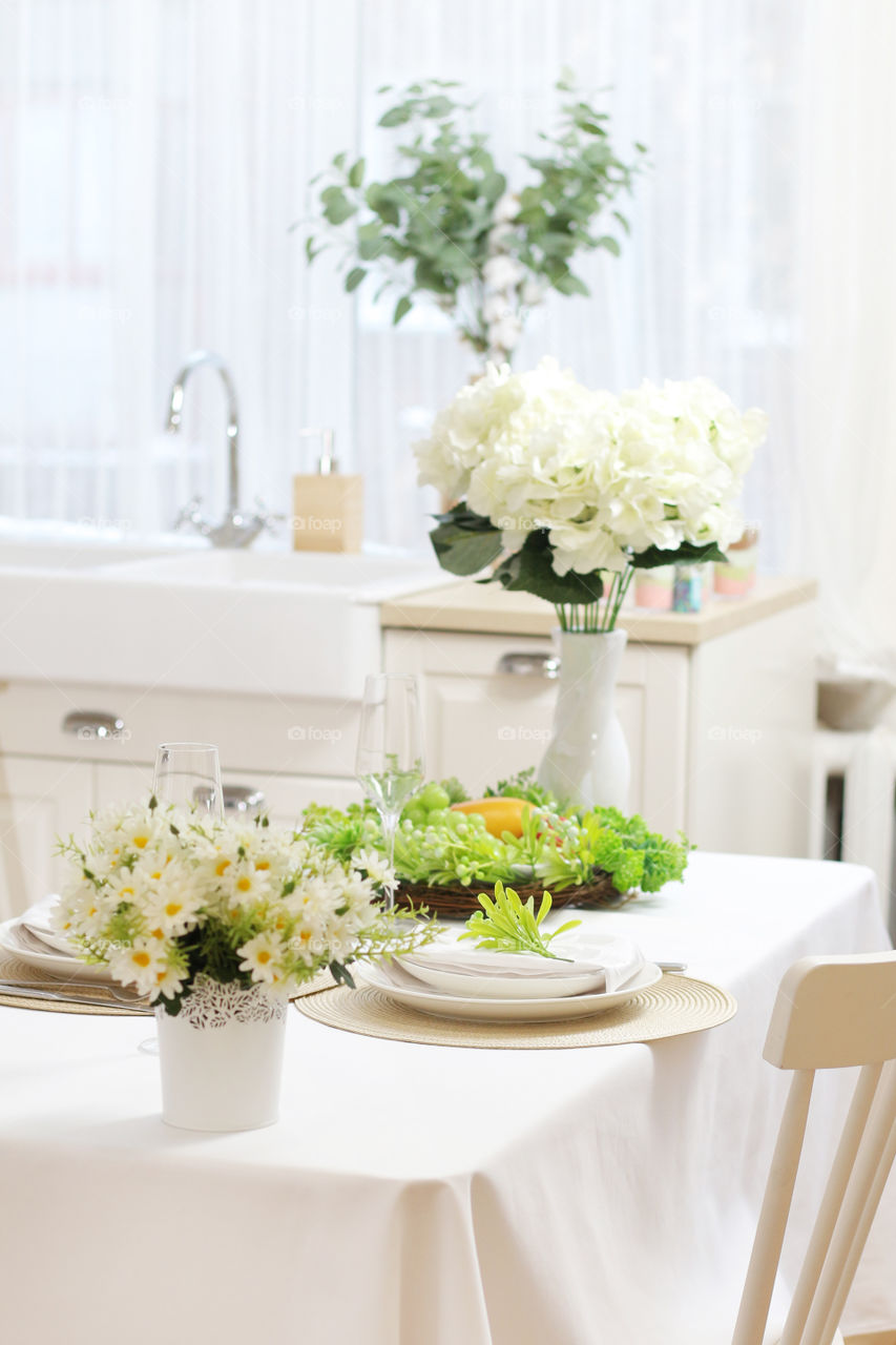 bright and cozy kitchen decorated with flowers, set table