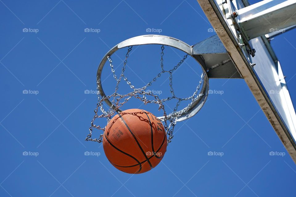 Basketball ball flying into the basket