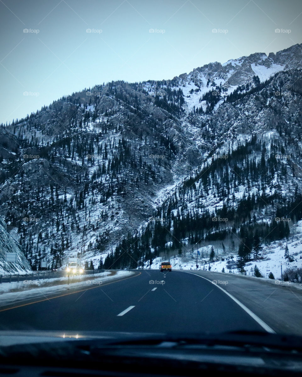 A snow covered mountain range along the highway.