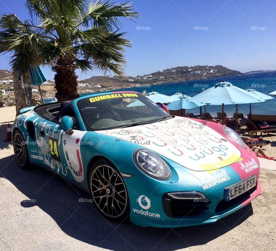 Porsche Gumball 3000 race car on a beautiful coast of Mykonos island, Greece