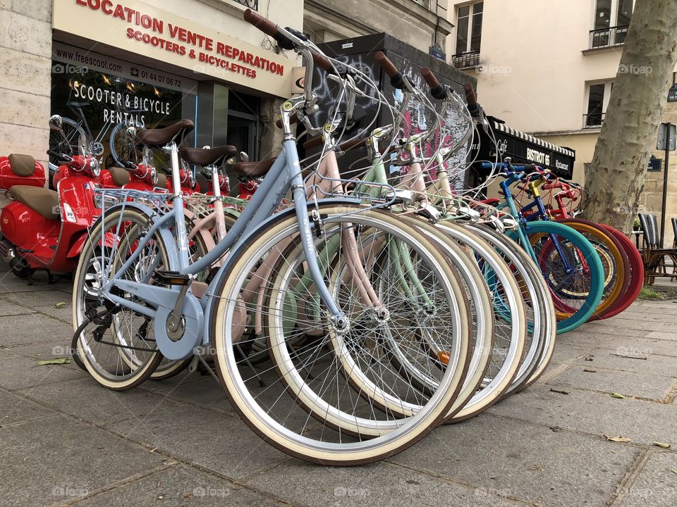Busy day, busy picture. Many modes of transportation within one photograph. Vintage bicycles all different colours, powered by human not machinery, you feel empowered, like you’re ready to conquer the day in the heart of Paris.