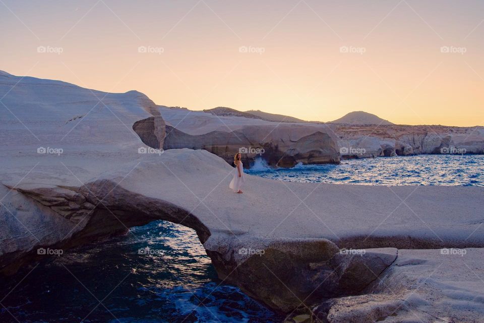 Young woman standing in a Rocky beach in Milos , Greece 