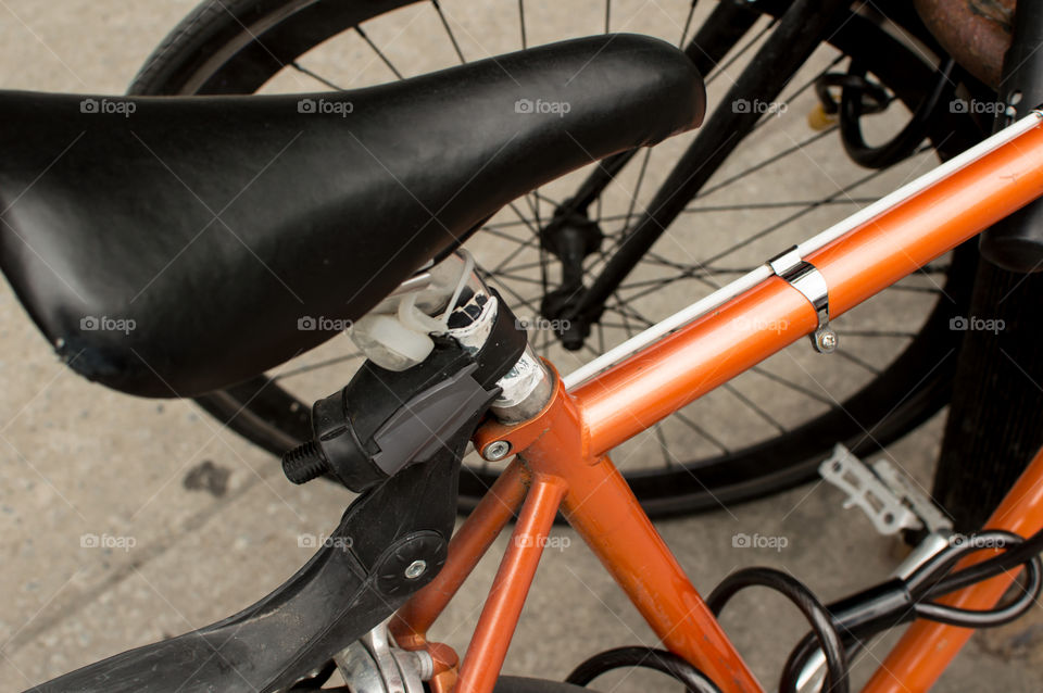 Orange bicycle elevated view of frame, seat, wheel and lock conceptual cycling and healthy lifestyle urban photography 