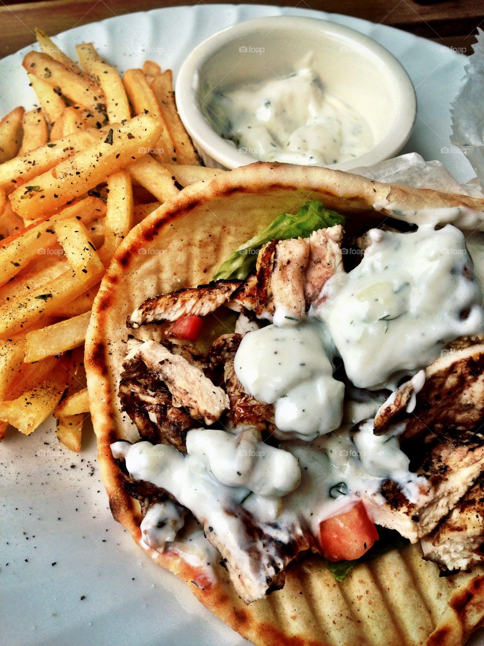 Fresh Chicken Gyro with seasoned fries. A Greek styled chicken gyro in pita bread with French fries and tzatziki sauce