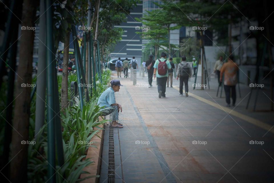 old man sitting on sidewalk alone. 28/11/2019