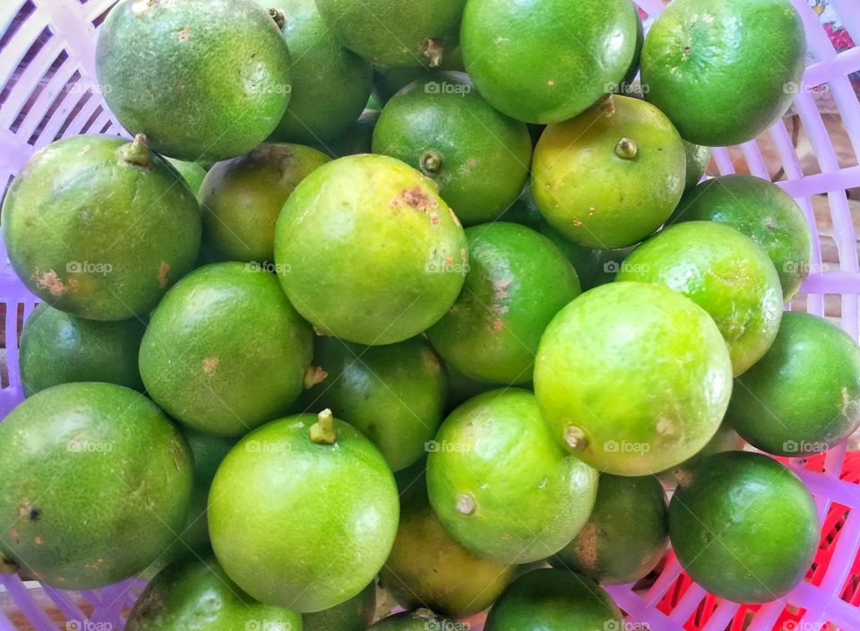 Citrus fruit, lime in a plastic basket. lime at fresh fruit market.
