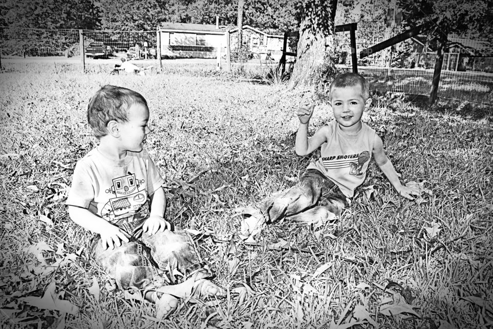 Boys playing in the grass in the front yard