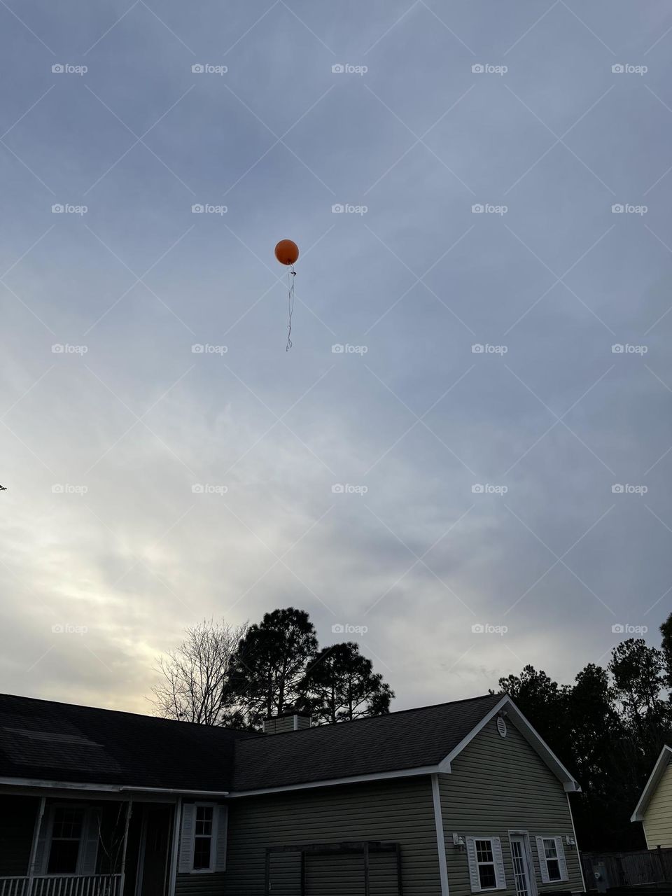 Evening Sky with clouds and lonely Red Balloon Floating off 