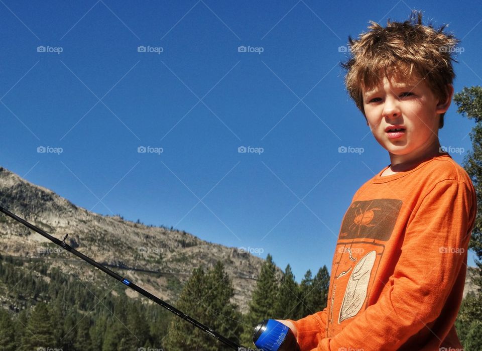 Little Boy Fishing In A Mountain Lake. Fishing In The Summertime
