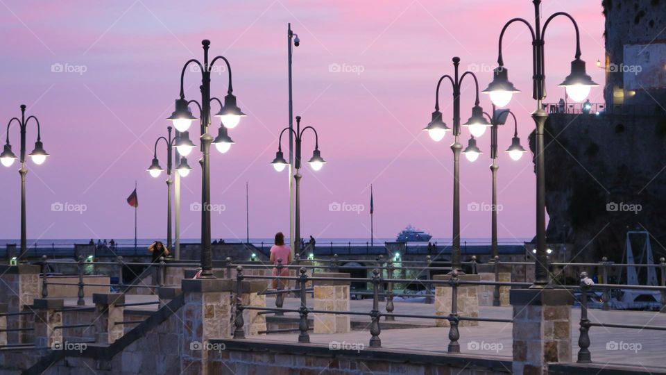 Sunset in the city. Pink colours sunset. Lanterns in the city. Evening time.