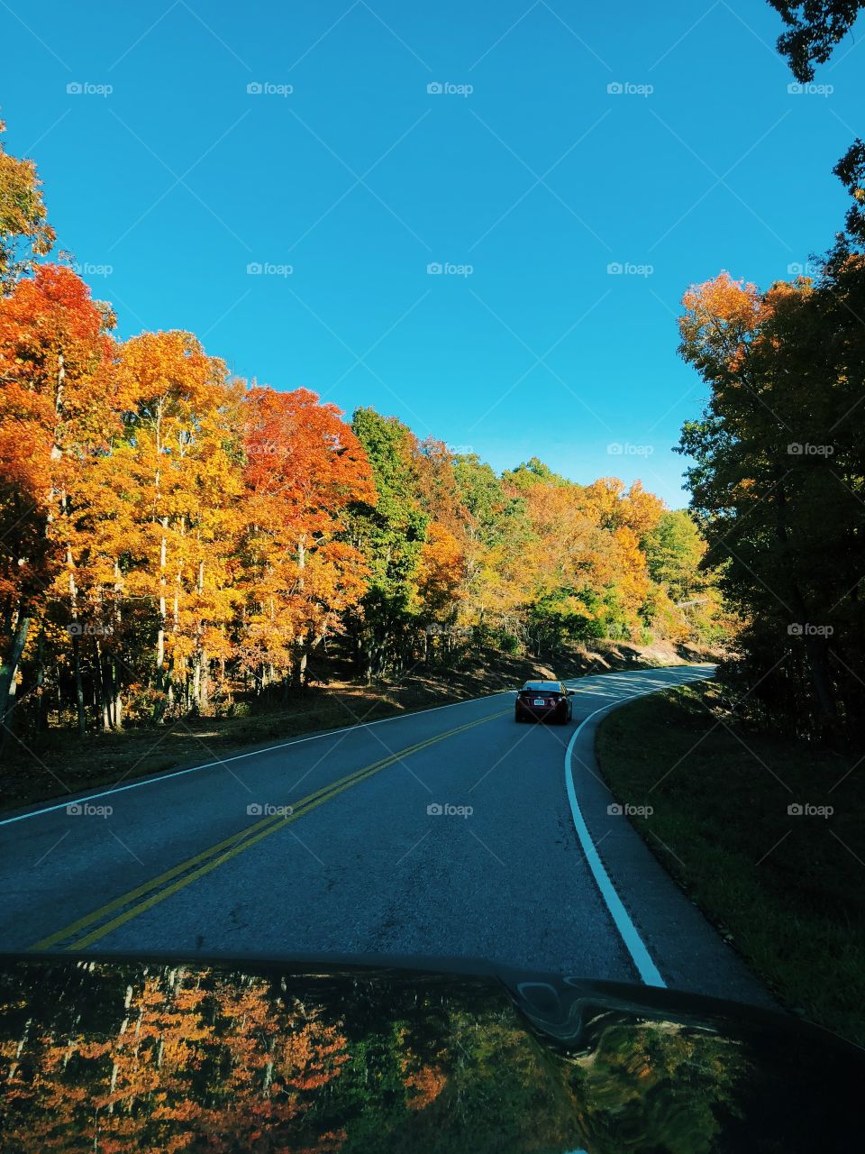 Driving through the winding mountains in Mark Twain National Forest in an autumn day