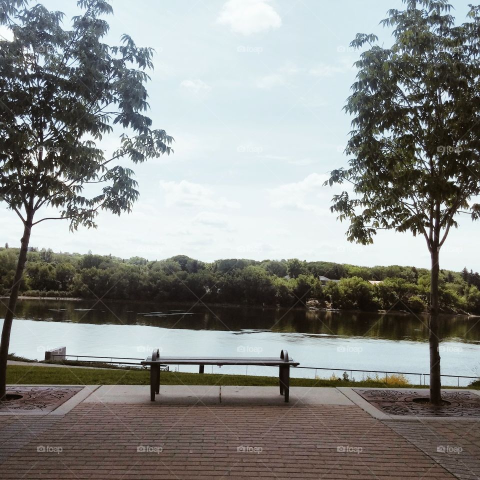 unoccupied bench by the water