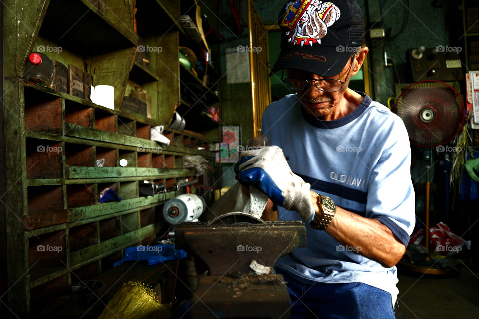 a worker at a machine shop fixes a motorcycle engine part