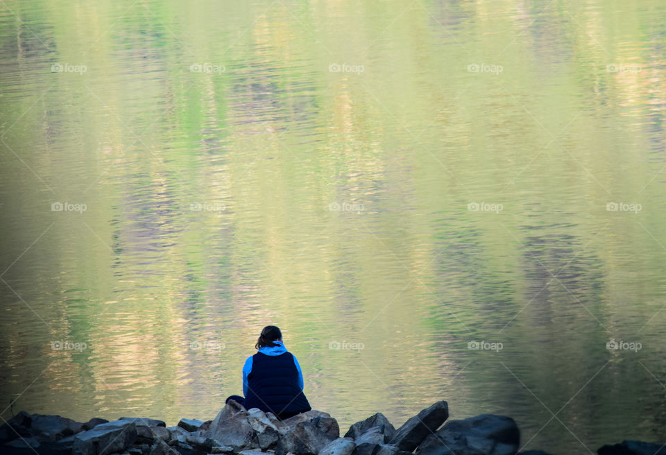 A serene place which shows the reflection of green plants and mountains on the lake 