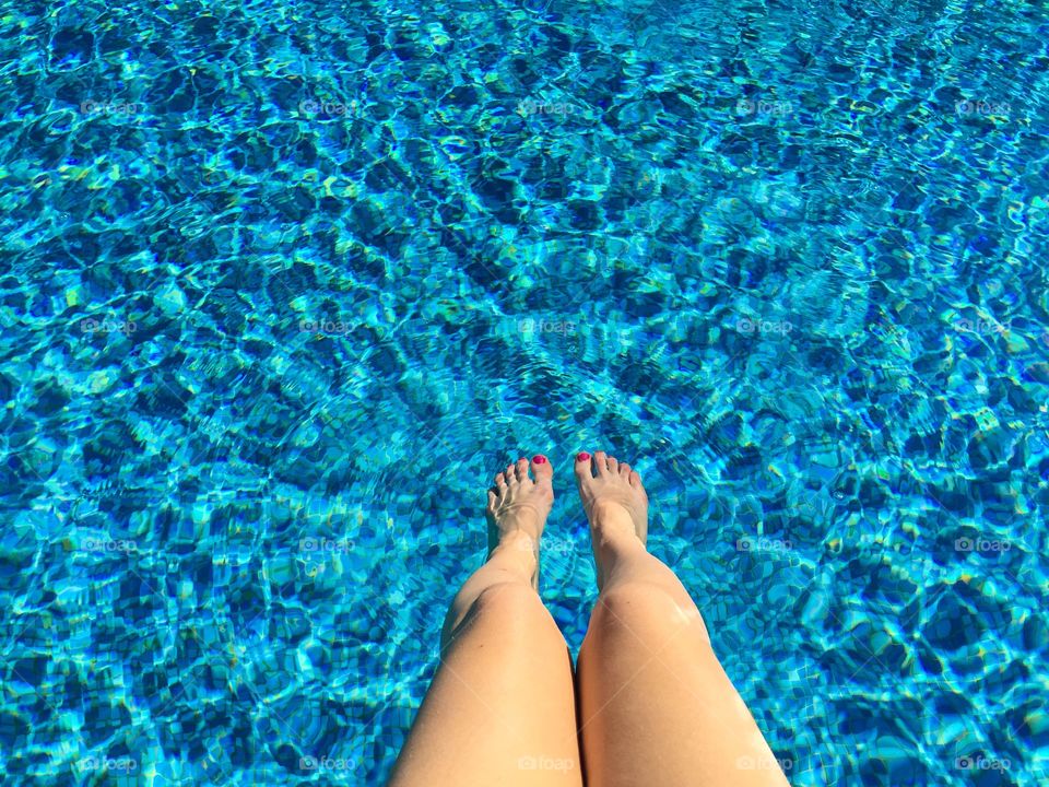 Looking down at woman’s legs in the pool