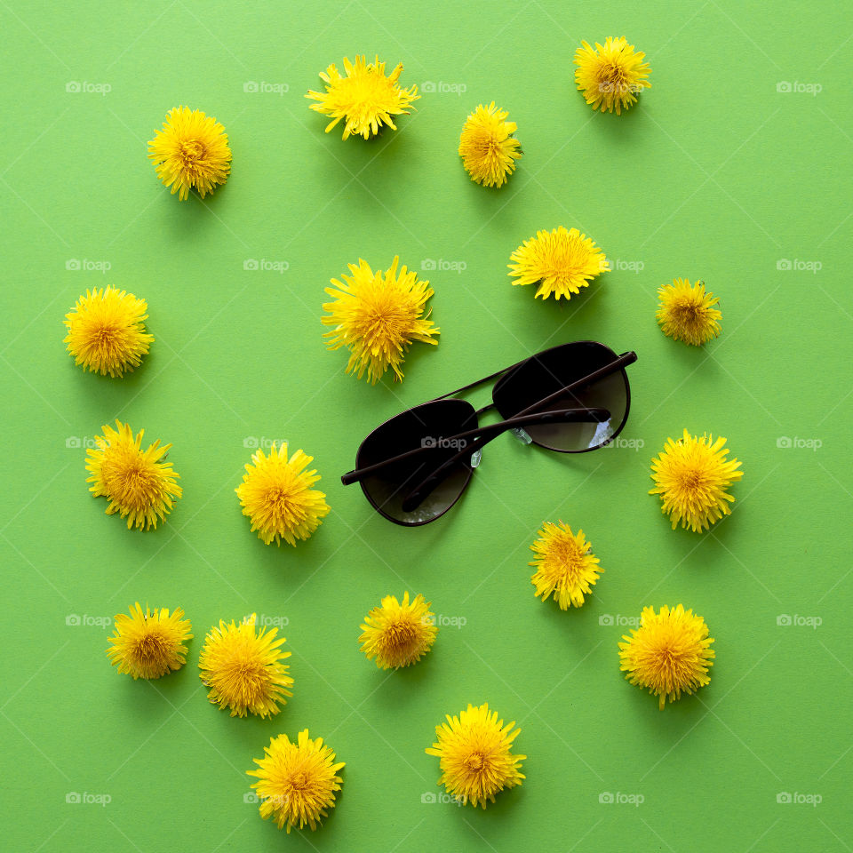 Summer flat lay with dandelions flowers and sunglasses