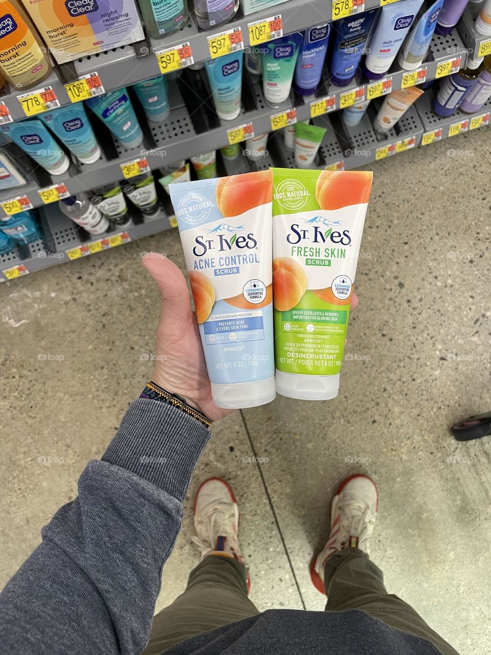 Woman shopping for face wash in Walmart, woman’s hand holding face dash in store, deciding what to buy, daily tasks for your household
