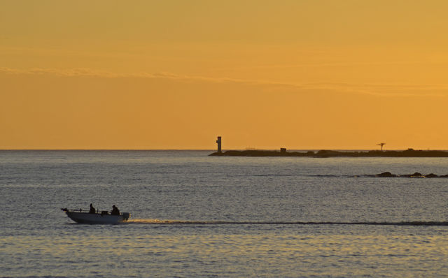 People travelling in boat at sunset