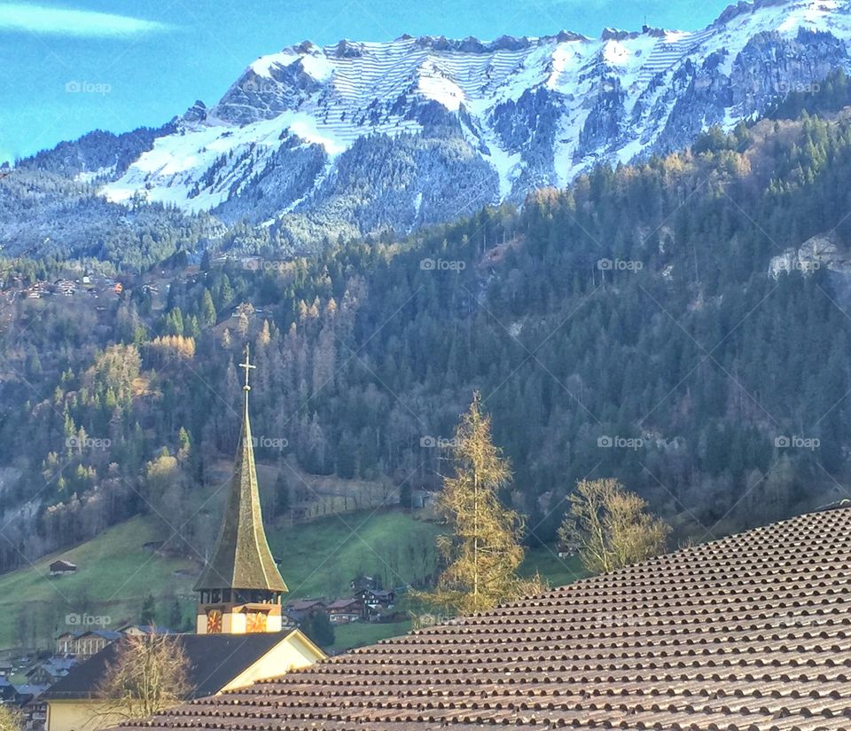 Church steeple against scenic mountain backdrop 