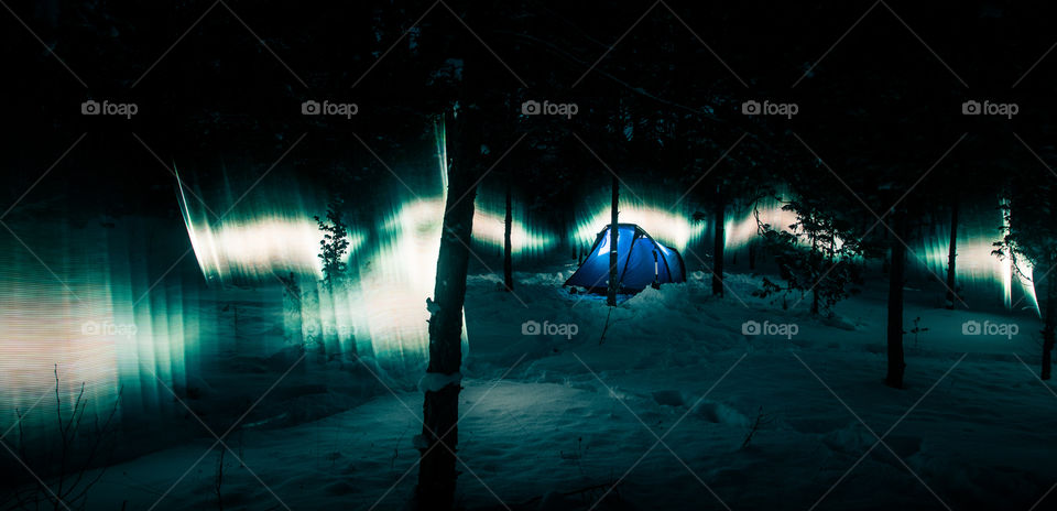 Aurora look alike in the winter forest with tent.