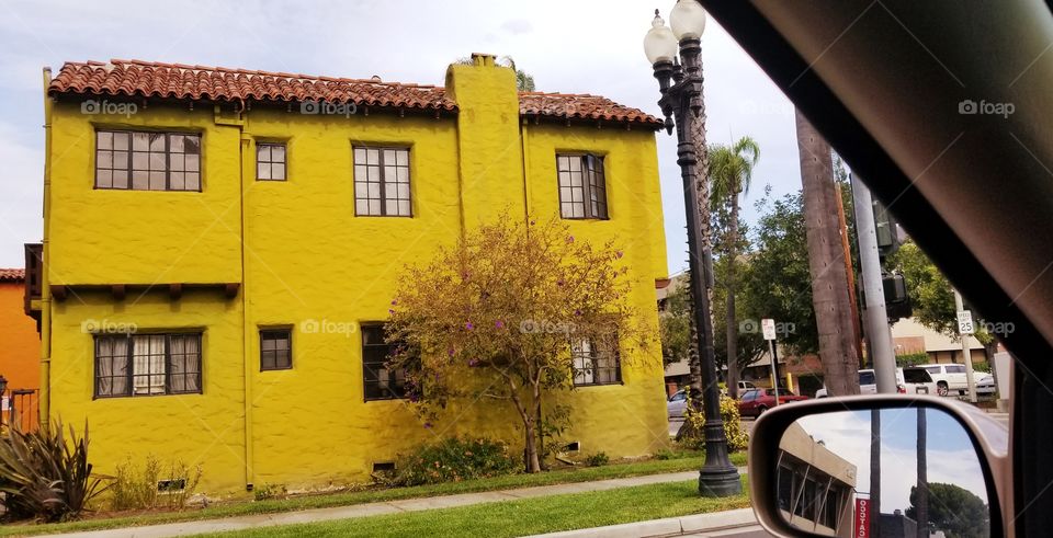 Yellow apartment building with lots of windows, as seen from my car window