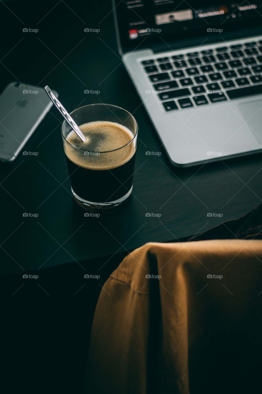 clear glass drinking glass beside MacBook Pro