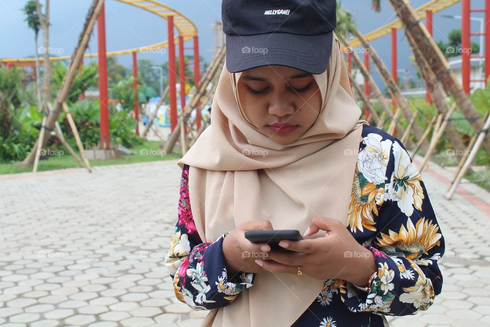 A young woman is holding a smartphone