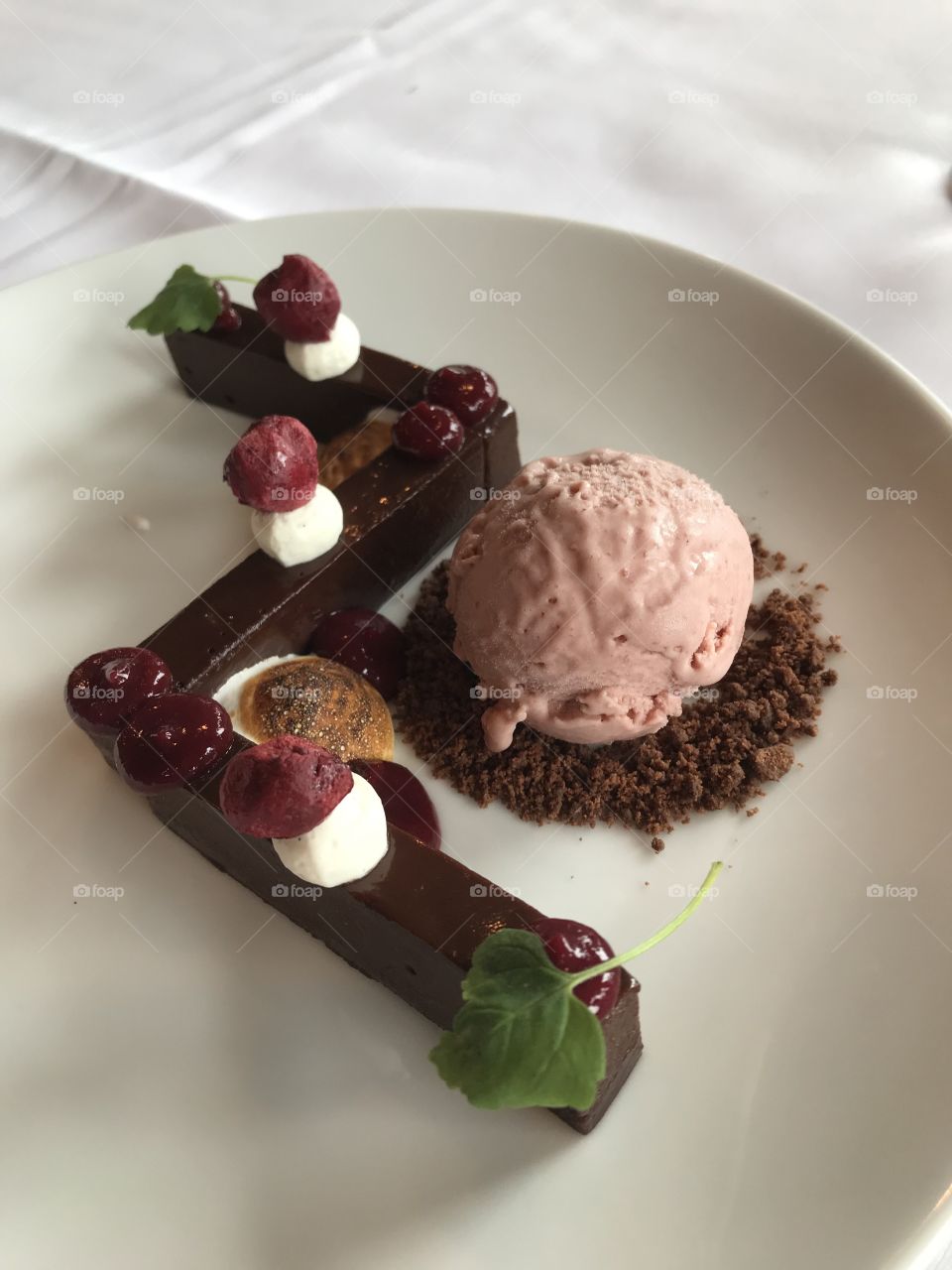 What a decadent dessert! A divinely rich dark chocolate ganache form with sour cherry purée, freeze dried cherries on drops of whip cream, toasted meringue, sour cherry & bourbon ice cream on a bed of cocoa crumbs & tiny fresh picked mint leaves. Yum