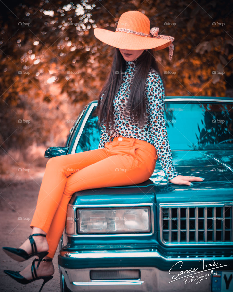 a cowboy girl sitting on the vintage classic Cadillac