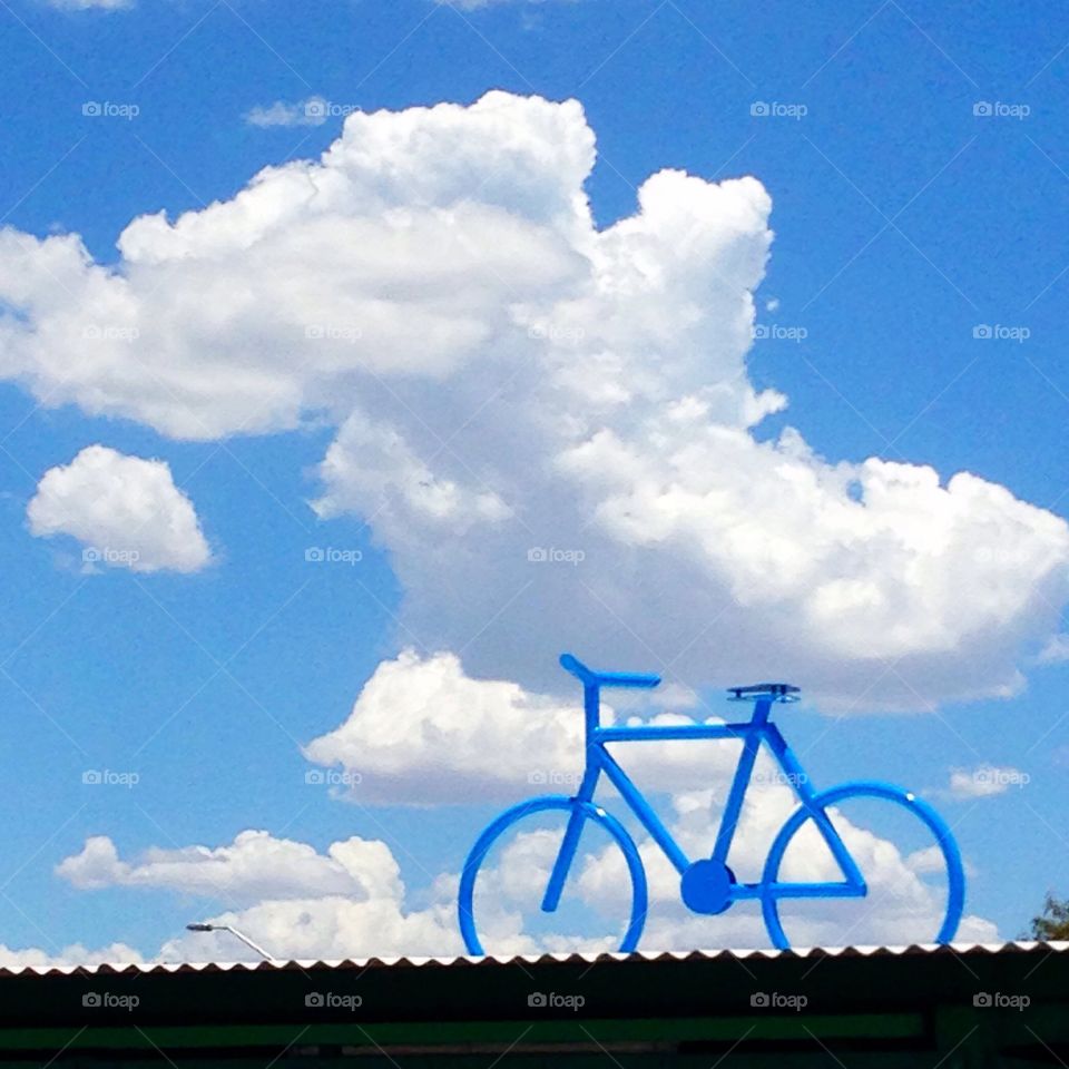 blue bicycle against white cloud