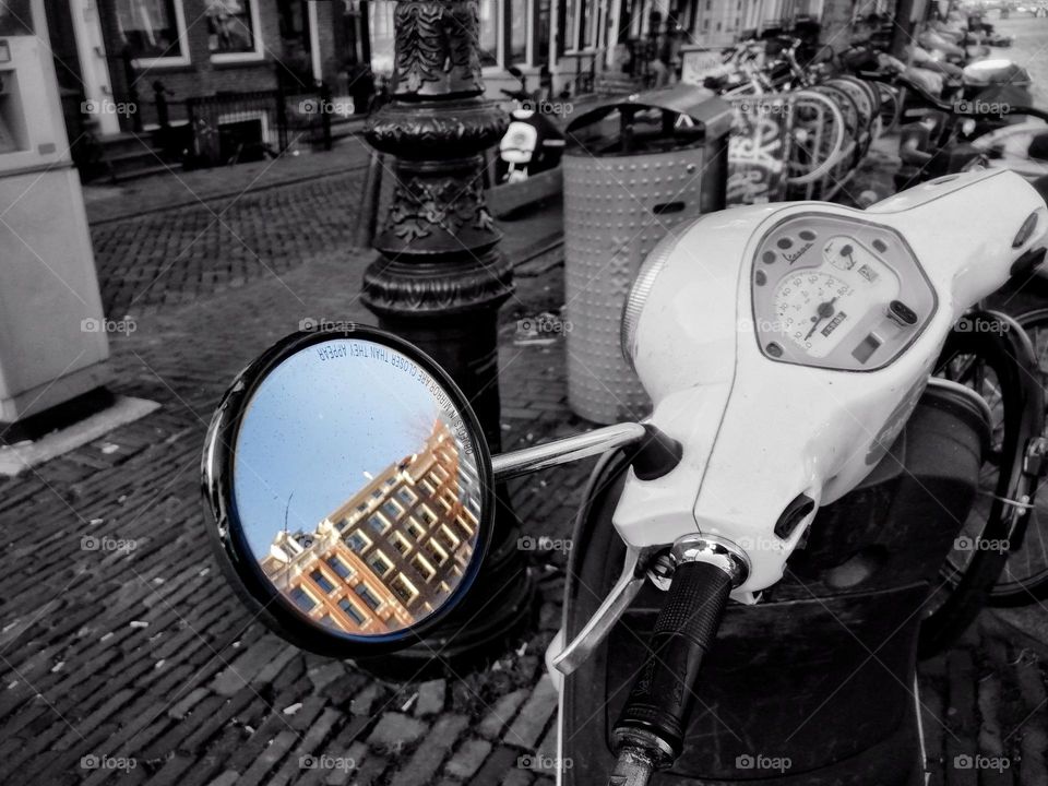 City reflection in the moped's mirror