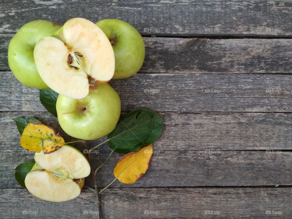 Green apples on aged wooden table.