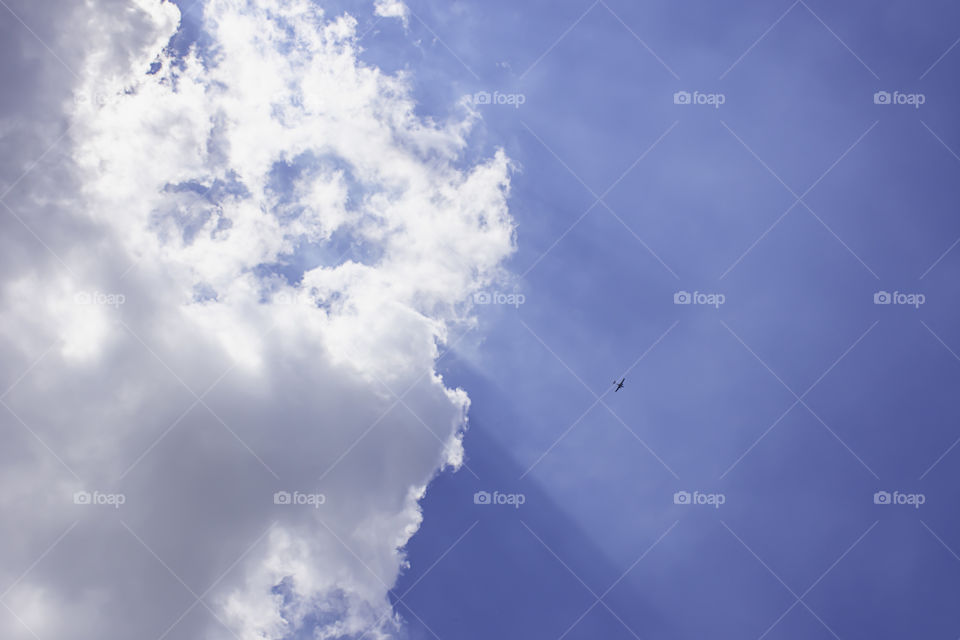 The beauty of the sky with clouds and the sun And the shadow of the plane.