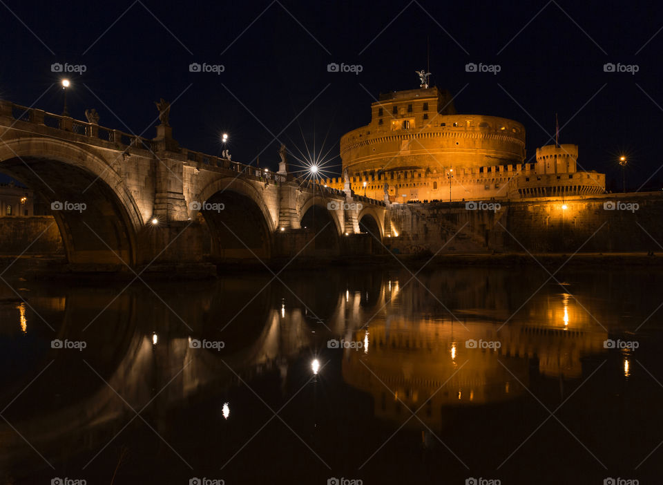 View of Castle Sant' Angelo with bridge from across the river. Rome at night.