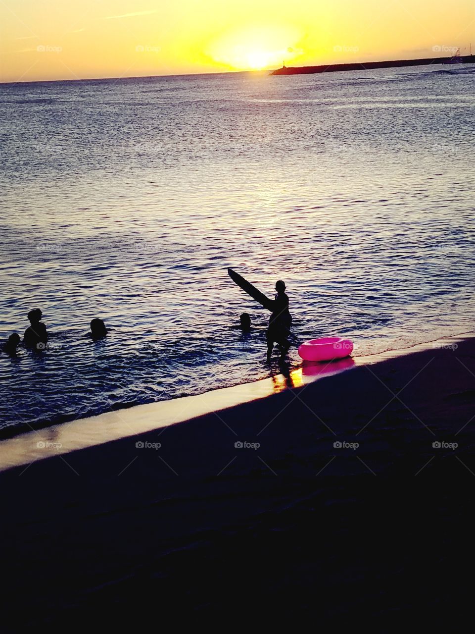 Kids still swimming as the sun goes down at Pokai Bay