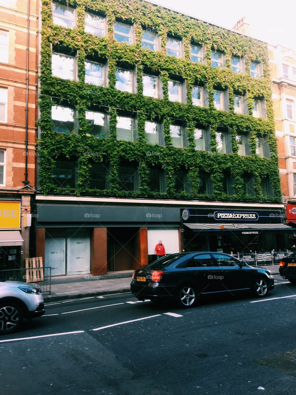 Building of Pizza express in London with vines and leaves over the windows