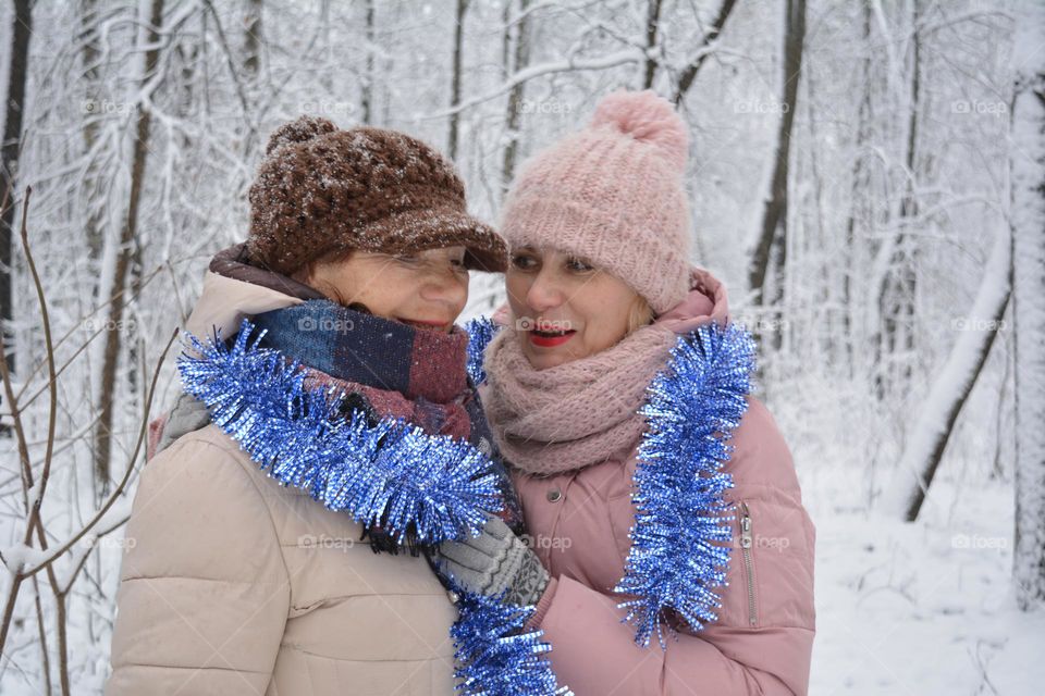 mother and daughter in the winter snowy park Christmas time winter holiday