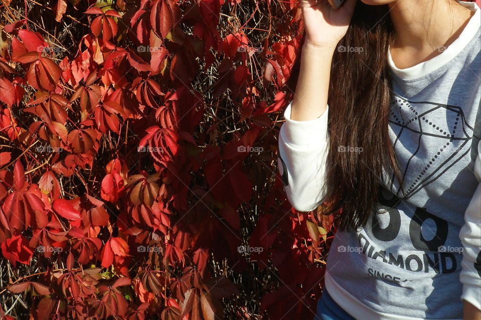 girl on a background of red autumn leaves