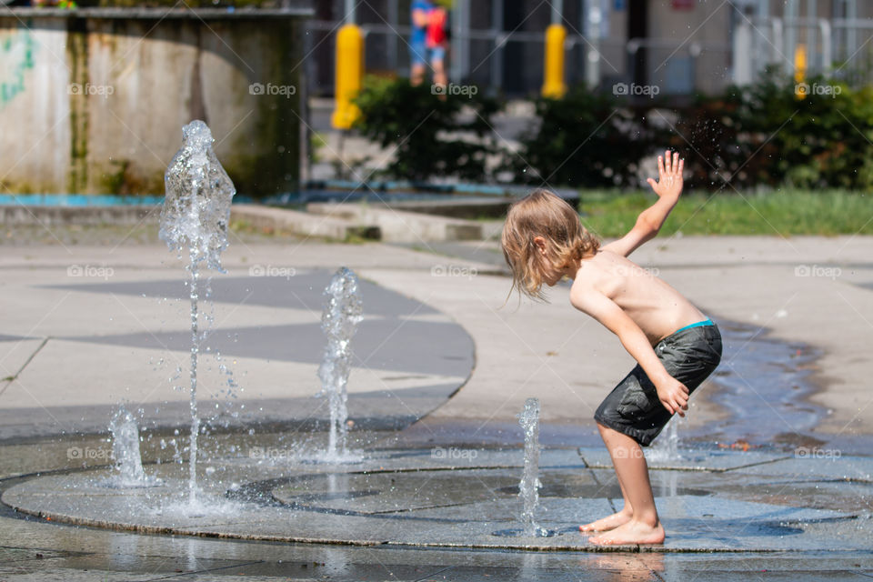 A boy playing in water. Hot summer.